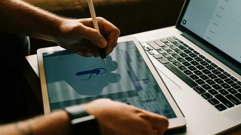 A modern workspace featuring a high-end graphic design tablet alongside a sleek laptop.